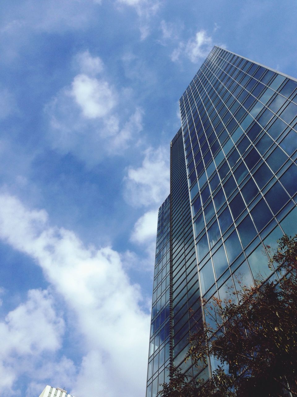 building exterior, architecture, modern, built structure, skyscraper, low angle view, office building, tall - high, city, tower, sky, glass - material, reflection, cloud - sky, building, cloud, tall, day, cloudy, outdoors