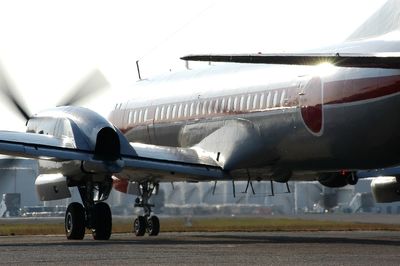 Airplane on airport runway against sky
