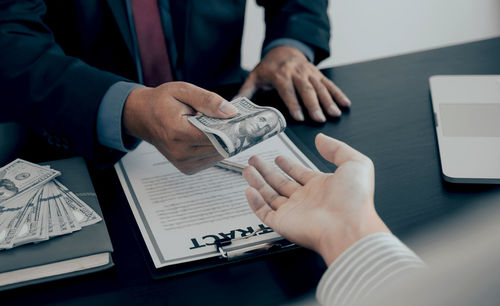 Midsection of couple holding hands on table