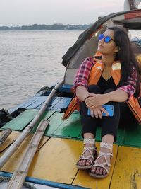 Woman sitting on boat in sea