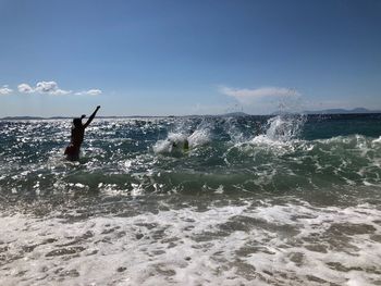 Man surfing in sea against sky