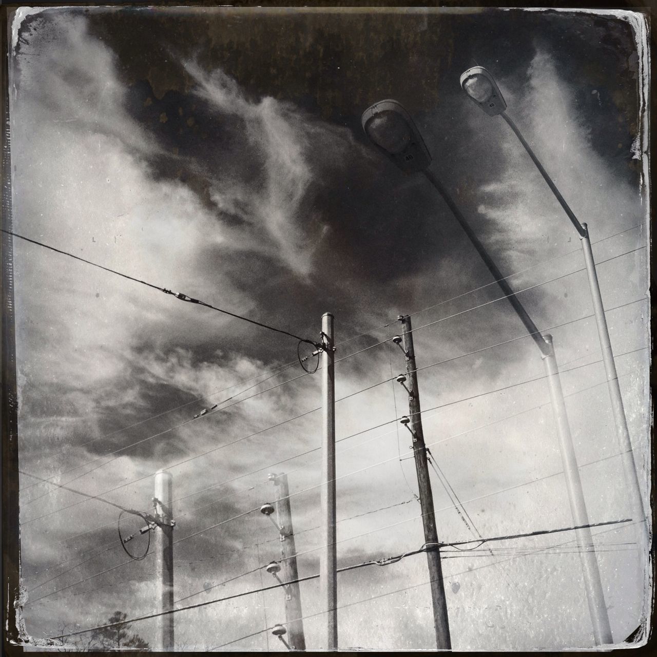 sky, cloud - sky, transfer print, low angle view, cloudy, power supply, power line, fuel and power generation, electricity, auto post production filter, technology, weather, electricity pylon, connection, cloud, overcast, cable, day, no people, industry