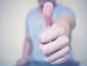 Midsection of man showing thumbs up