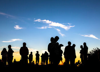 Silhouette people standing against sky