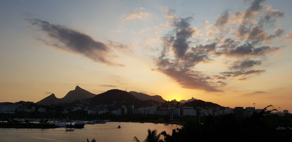 Panoramic view of townscape by sea against sky during sunset