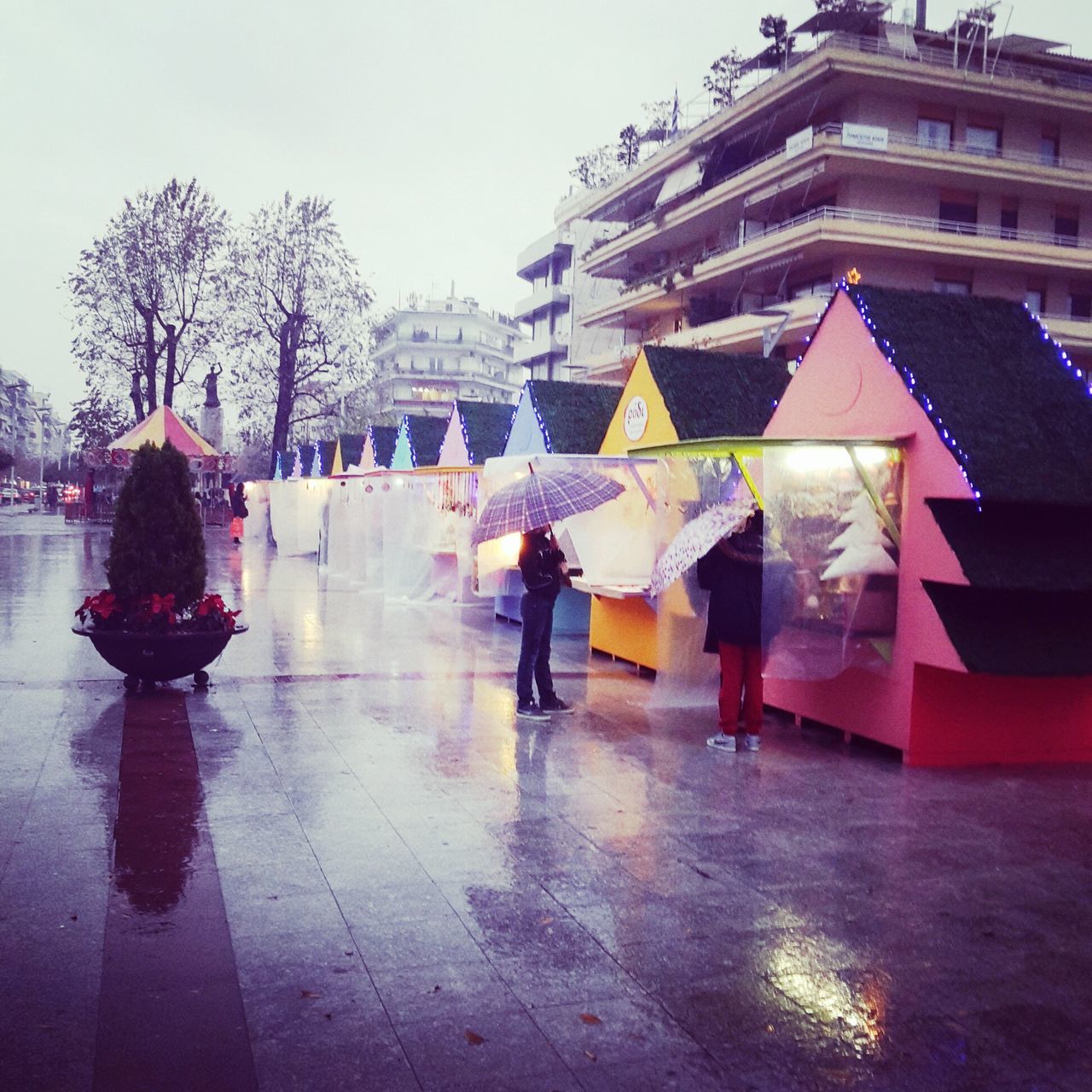 architecture, built structure, building exterior, umbrella, men, tree, lifestyles, person, city, clear sky, walking, building, day, leisure activity, full length, outdoors, street, sky