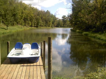 Pedal boat on jetty in river amidst trees