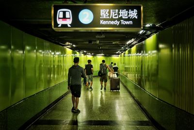 Rear view of people walking in subway