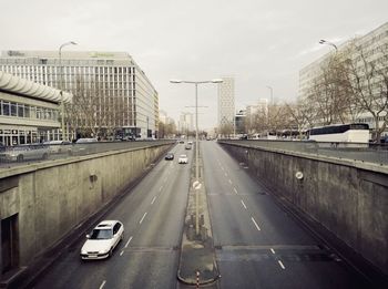 Cars on road in city against sky