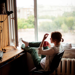 Woman relaxing on window