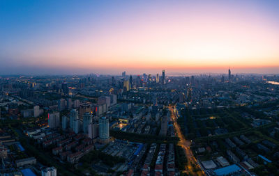 High angle view of illuminated buildings against sky during sunset