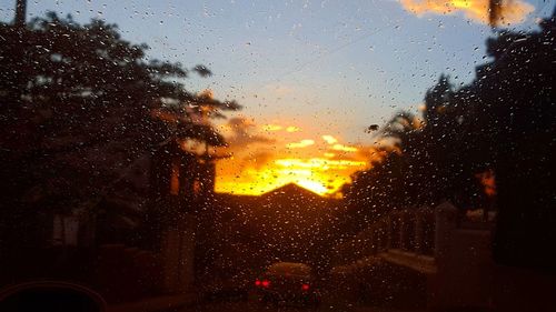 Raindrops on glass window during sunset