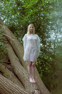 Full length of a woman standing in forest