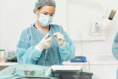 Dentists holding dental equipment at clinic