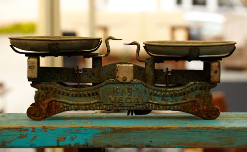 Close-up of old weigh scale on wooden plank