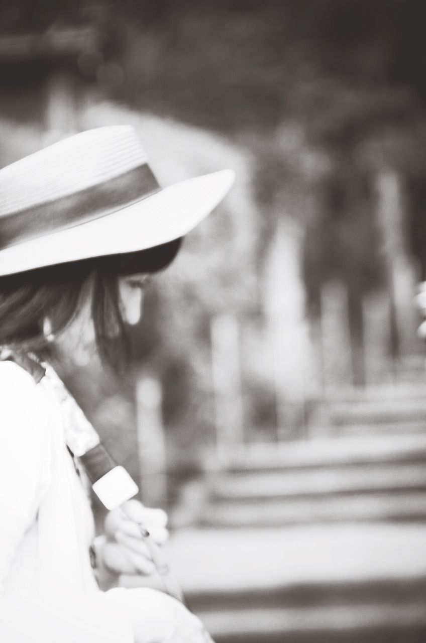 CLOSE-UP OF WOMAN HOLDING HAT WITH UMBRELLA