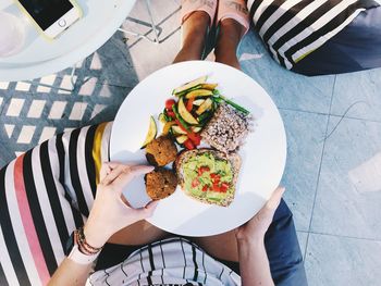 High angle view of woman holding food in plate