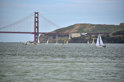 View of suspension bridge over sea against sky