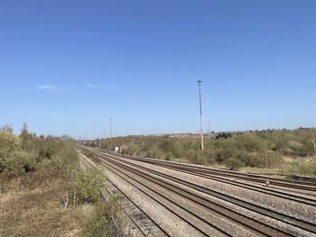 Railroad tracks against clear blue sky