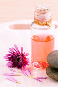 Close-up of essential oil and flower on table