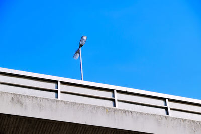 Low angle view of street light on bridge against clear blue sky