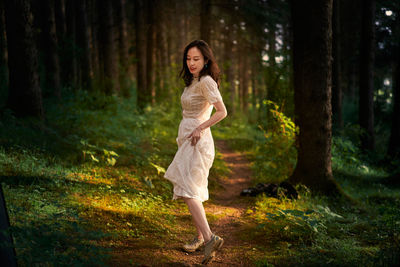 Young woman standing in forest