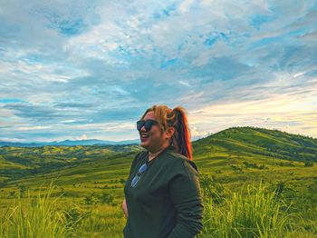 Woman standing on landscape against sky