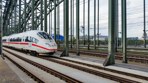 Train at railroad station in city against sky