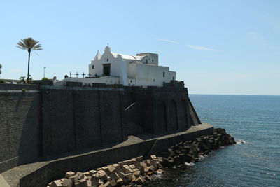 Building by sea against sky