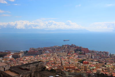 High angle view of townscape by sea against sky