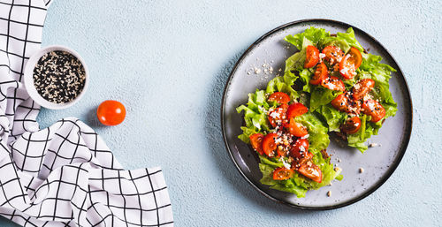 Sandwich with tomatoes and lettuce on rye bread on a plate on the table top view web banner