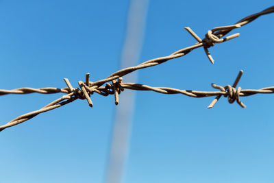 Low angle view of barbed wire against clear sky