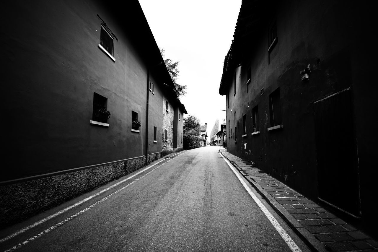 EMPTY ROAD AMIDST BUILDINGS AGAINST SKY