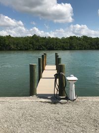 Boardwalk by lake against sky