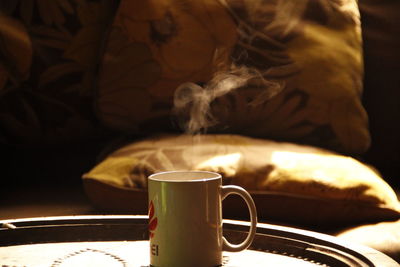 Close-up of coffee cup on bed