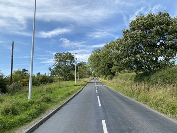 Looking up, hall green lane, with grass verges, on a sunny day in, north rigton, harrogate, uk