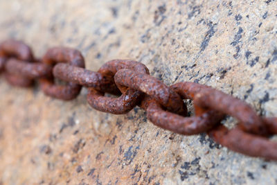 Close-up of rusty chain on rock