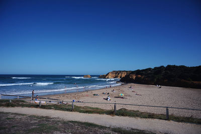 Scenic view of beach against clear blue sky
