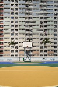 View of basketball hoop against buildings in city