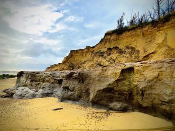 Low angle view of rock formation on beach against sky