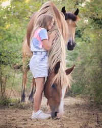 Full length of girl embracing while standing in farm