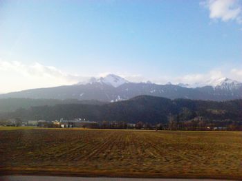 Scenic view of agricultural field and mountains against sky