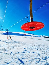 Ski lift hanging on snow covered field