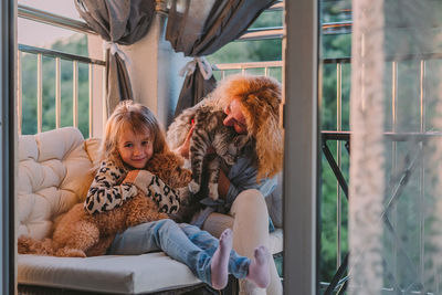 Happy child with smile plays on summer at home with mom, dog at sunset. cat, dog, pets family member