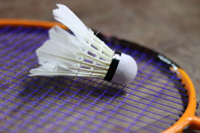 Close-up of shuttlecock with racket on table