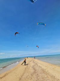 People enjoying at beach against sky