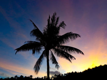 Silhouette palm trees against romantic sky at sunset