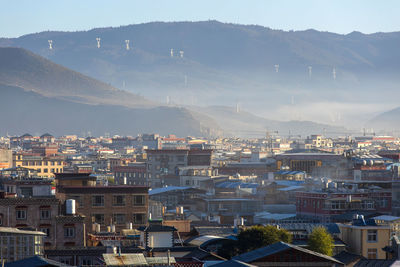 Cityscape and mountains against clear sky