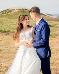 Portrait of smiling couple standing on field