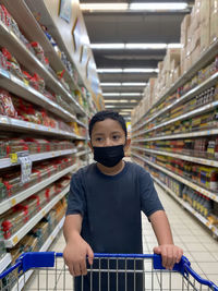 Rear view of kid wearing mask standing in store.